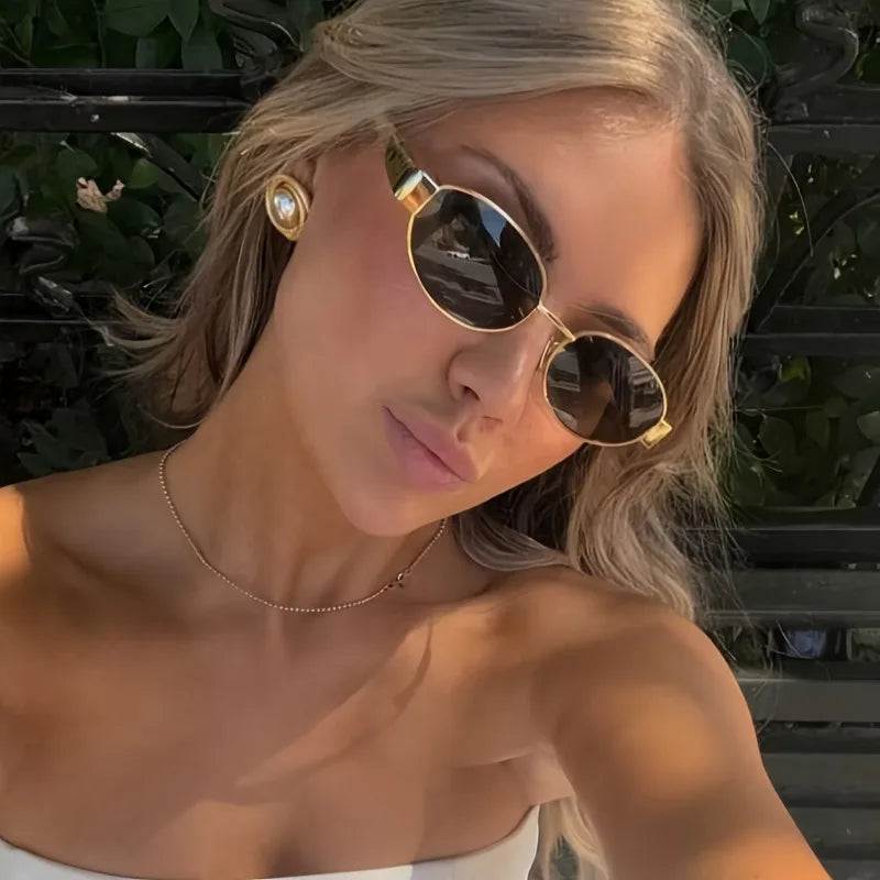 Lentes de sol de diseño redondo y montura de tono dorado para mujer