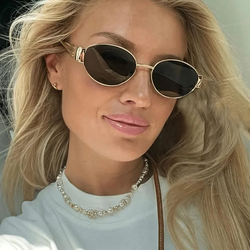 Lentes de sol de diseño redondo y montura de tono dorado para mujer